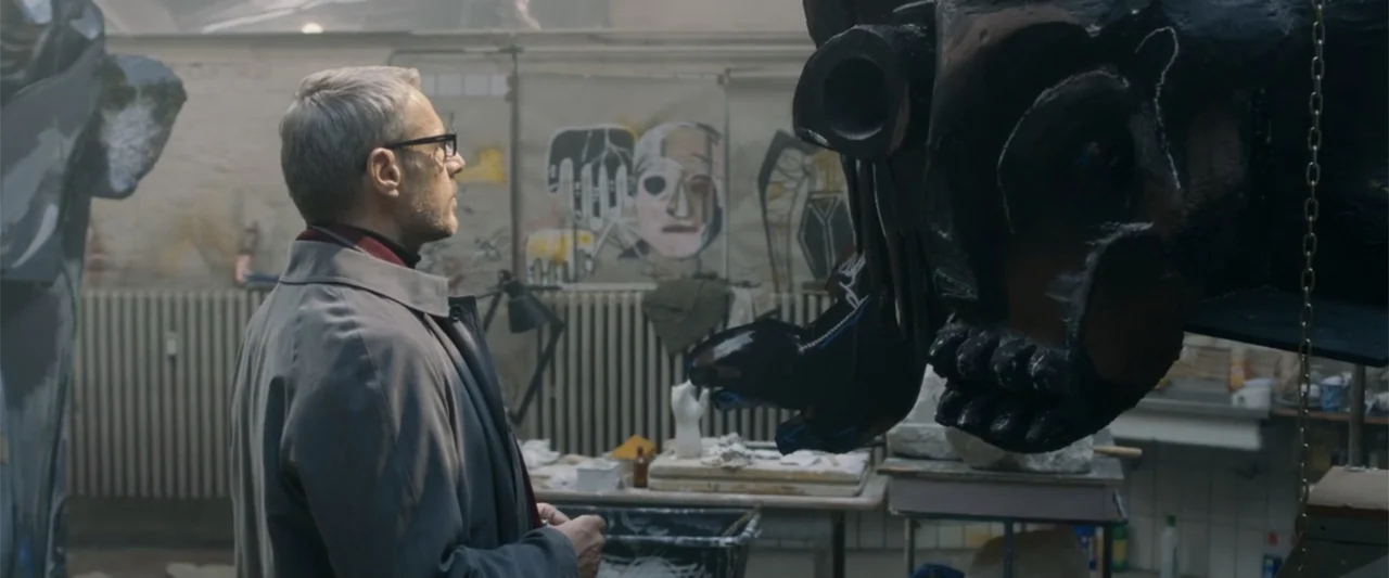 Heartburn (1986) movie still: medium — An industrial studio space contains canvases with sketches on the wall and sculptures. A middle-aged man in a…