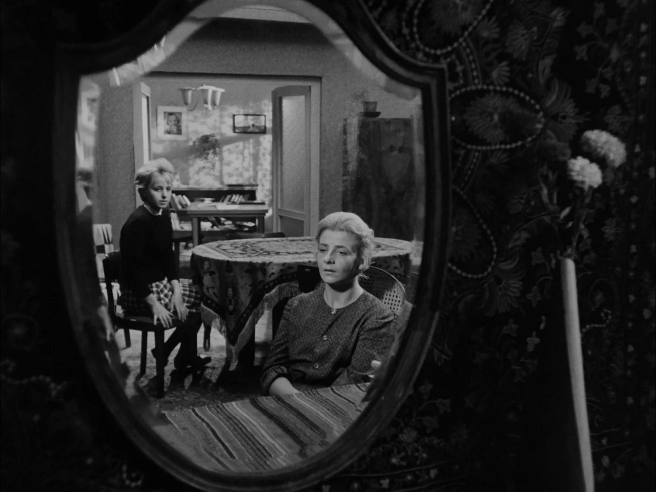 The Sun In A Net (1963) movie still: medium — A 1960s interior space features a table with a patterned cloth and mirror reflection. Two blonde women…