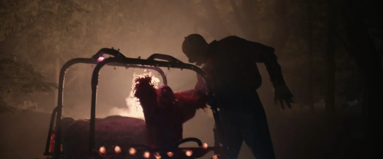 Winnie-the-Pooh: Blood and Honey 2 (2024) movie still: medium — A dark outdoor space at night with dense trees and a small vehicle. One person pulls…