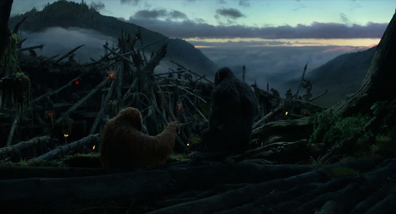 Dawn of the Planet of the Apes (2014) movie still: wide — A high vantage point overlooks a rugged encampment built from wooden sticks and debris.…