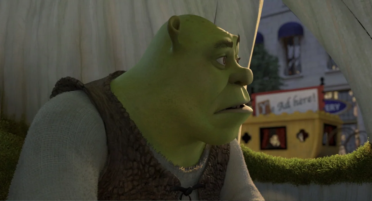 Shrek 2 (2004) movie still: medium — An ogre sits inside a covered wagon with light fabric walls and mossy edges. The green ogre gazes toward the…