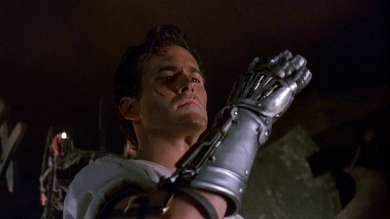 Army of Darkness (1992) movie still: medium — A dimly lit stone chamber with rough masonry and faint light from a candle. A man looks down at his…