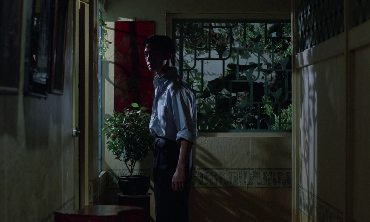 The Scent of Green Papaya (1993) movie still: medium — A dimly lit indoor passageway features patterned wall decorations and a wooden lattice…