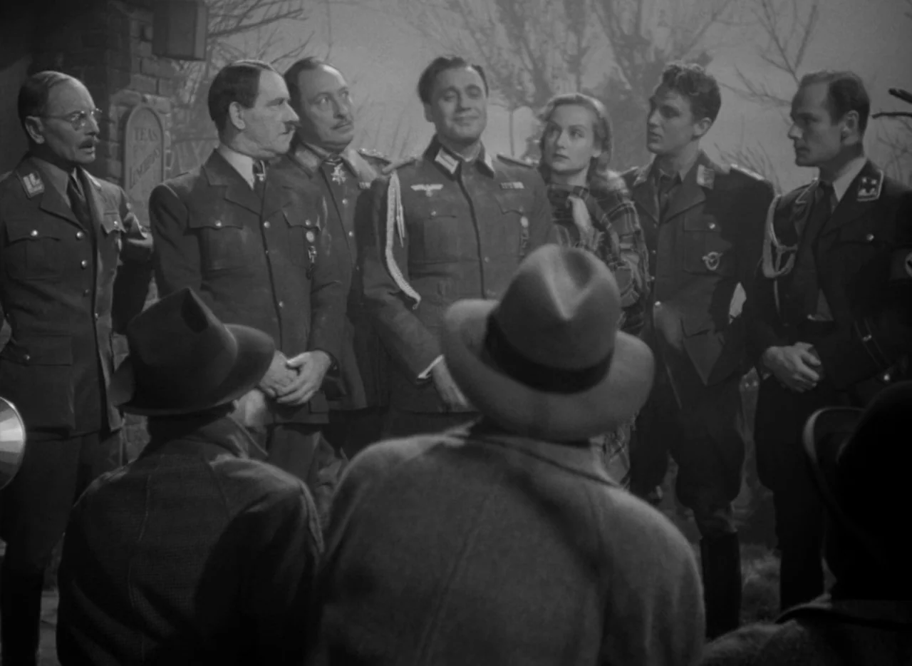 To Be or Not To Be (1942) movie still: medium — A group of men in military uniforms stand outdoors at night. Several individuals face each other in…
