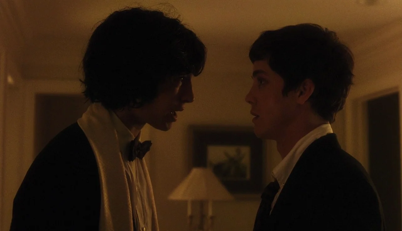 The Perks of Being A Wallflower (2012) movie still: medium — A dimly lit residential hallway at night with a framed picture on the wall. Two young…