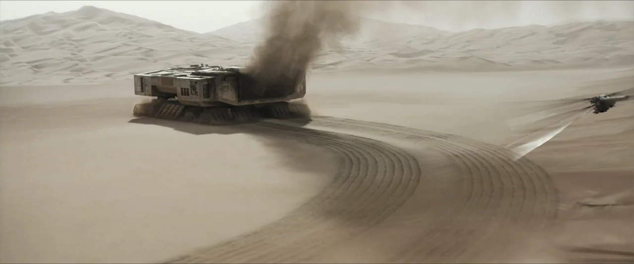 Dune (2021) movie still: wide — An arid, expansive desert landscape features endless dunes under a clear, bright sky. A large, weathered industrial…