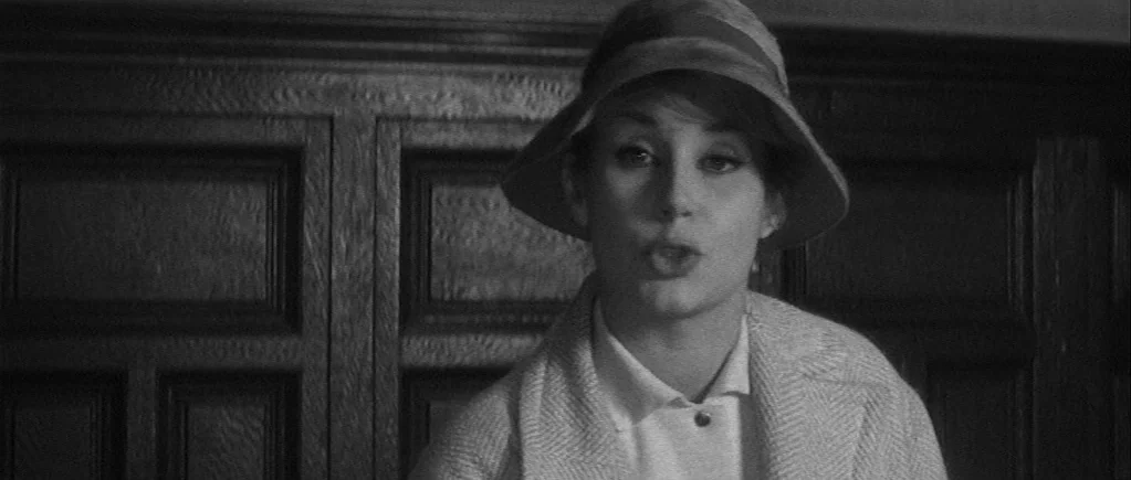 The 400 Blows (1959) movie still: medium — A woman stands in front of dark, ornate wood paneled walls. She is speaking directly toward the camera…