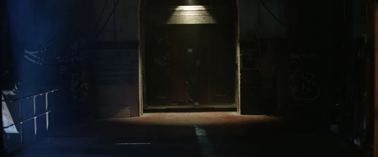 Winnie-the-Pooh: Blood and Honey 2 (2024) movie still: wide — A dimly lit industrial hallway features graffiti-covered walls and a central arched…