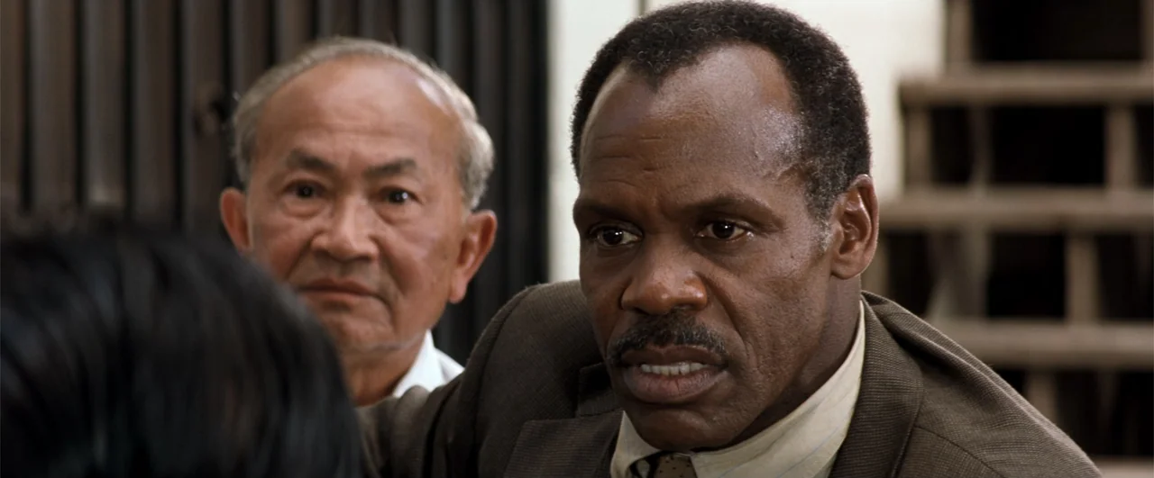 Lethal Weapon 4 (1998) movie still: medium — An interior space features two men positioned in front of wooden structures. A Black man in a brown…