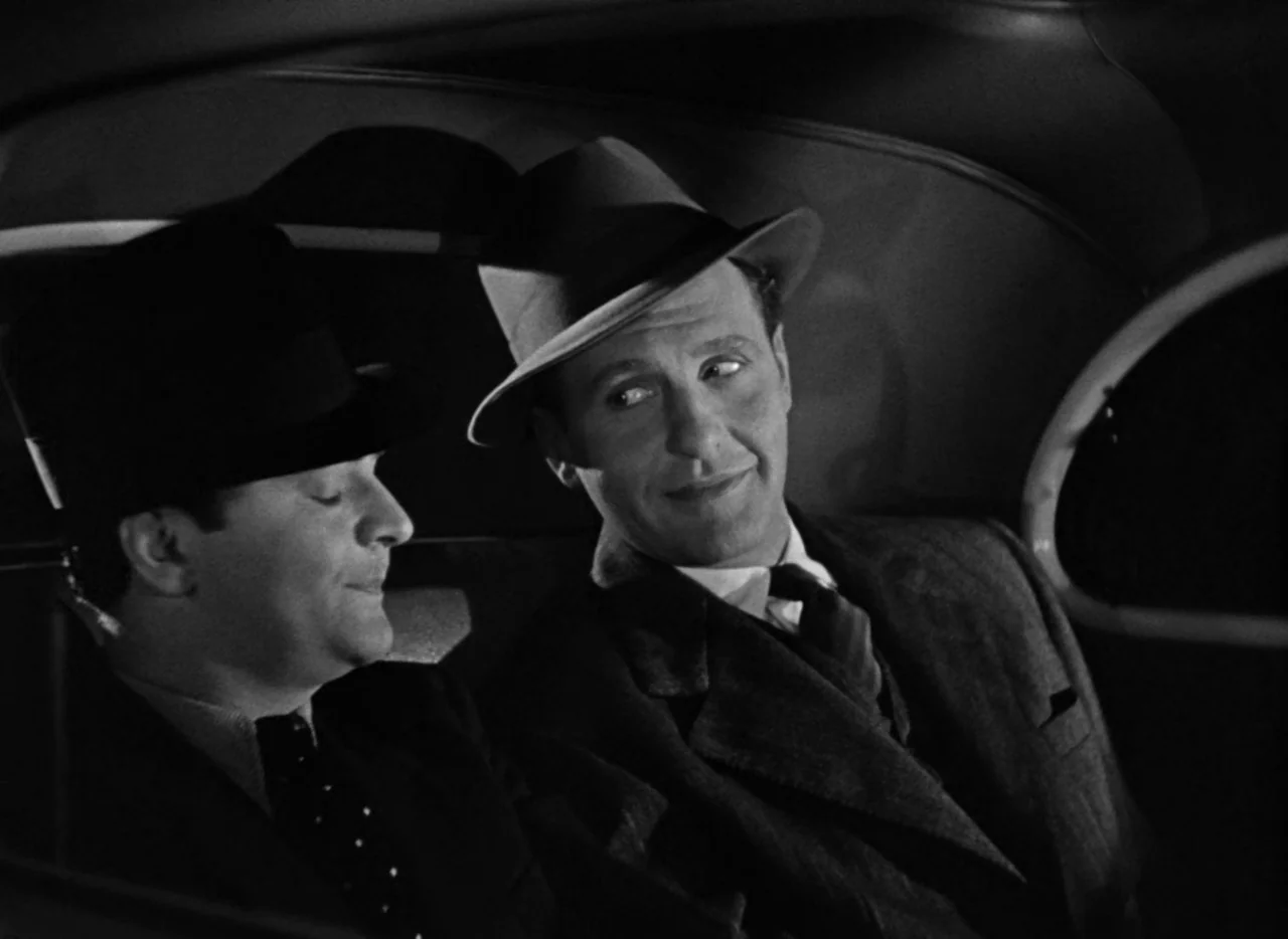 Dance, Girl, Dance (1940) movie still: medium — The interior of a vintage automobile at night with dark leather upholstery. Two men wearing formal…
