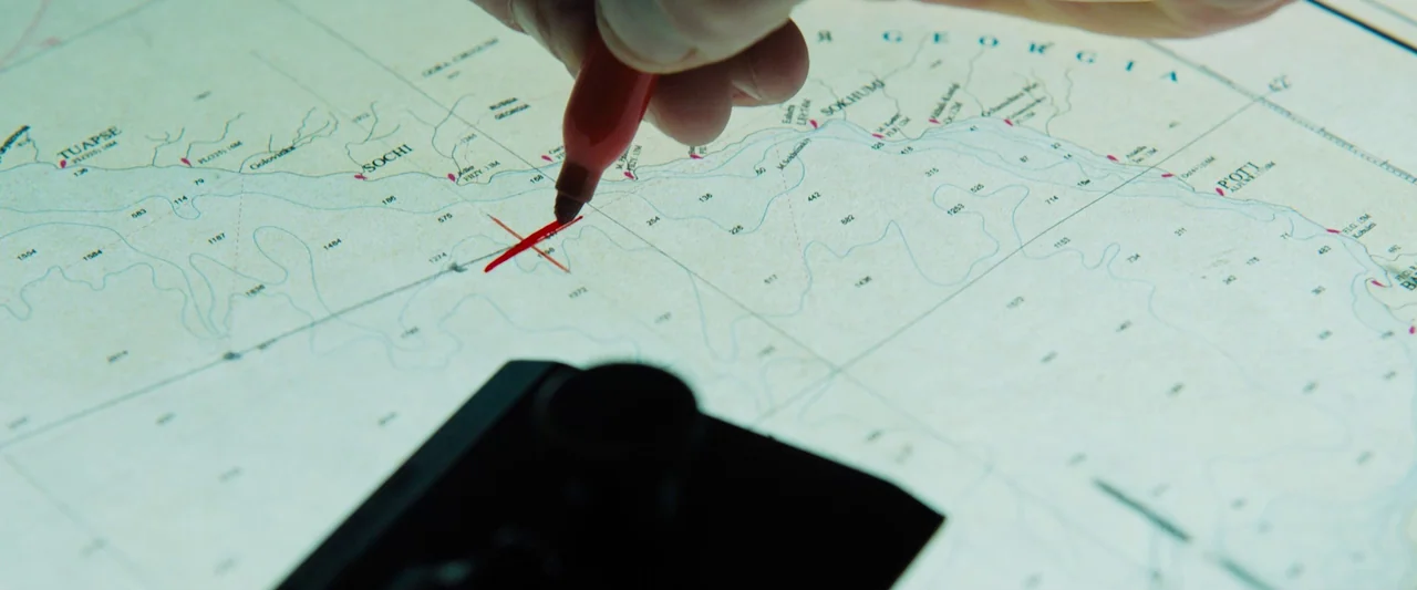 Black Sea (2014) movie still: closeup — A detailed nautical chart of the Black Sea rests on a flat surface. A red marker makes a precise mark over…