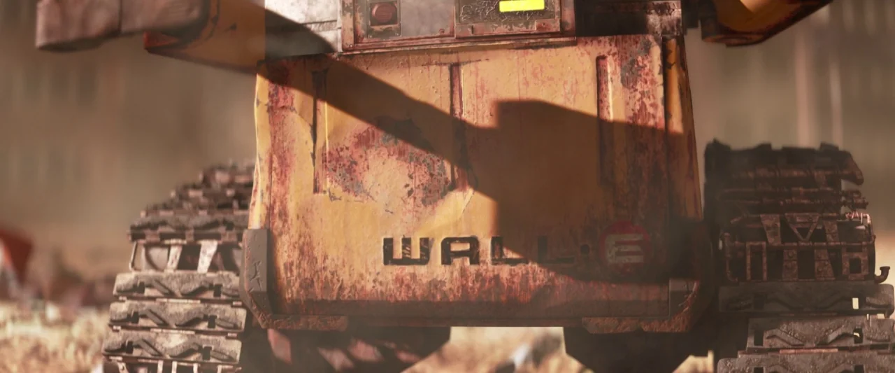 Wall-E (2008) movie still: closeup — A rusted, yellow industrial robot stands amidst a vast, dusty landscape of debris. The machine displays…