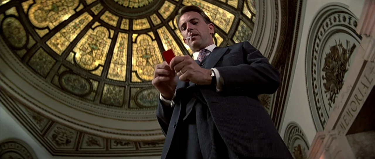 The Untouchables (1987) movie still: medium — A man stands beneath a large, circular, ornate stained-glass ceiling in a grand building. He holds a…