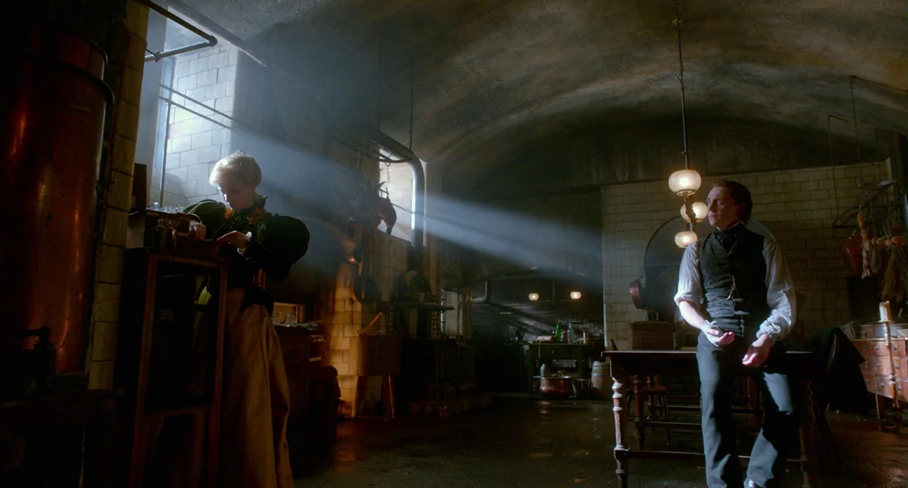 Crimson Peak (2015) movie still: wide — A subterranean kitchen with vaulted stone ceilings, tiled walls, and dim, earthy industrial lighting. A…