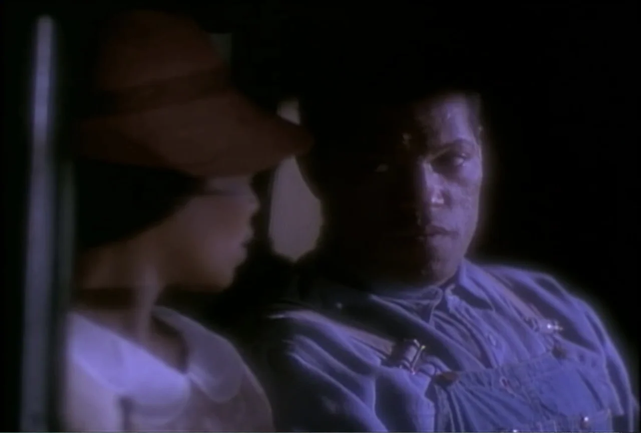 Miss Evers' Boys (1997) movie still: medium — Two individuals sit inside the dark cabin of a vintage vehicle. A man and a woman are positioned…