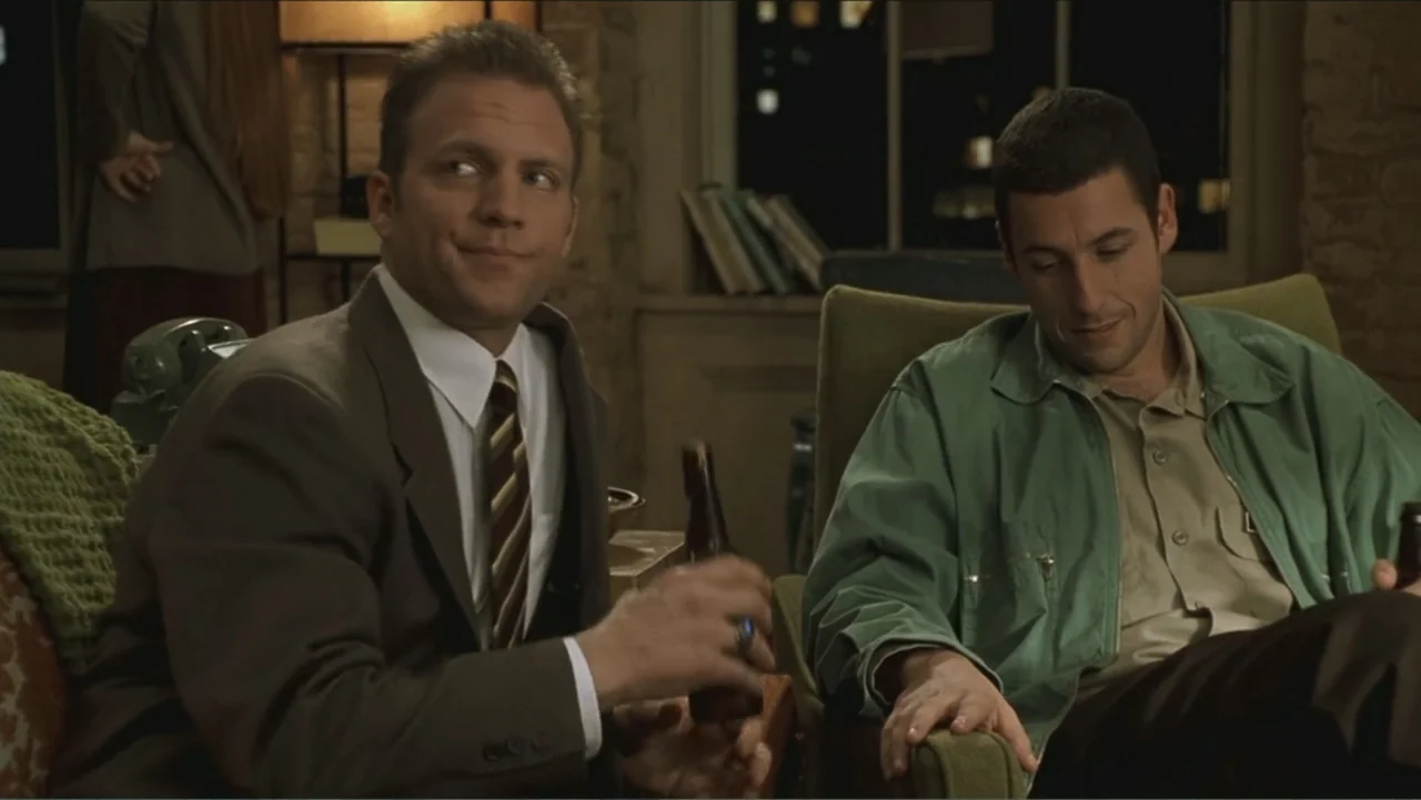 Big Daddy (1999) movie still: medium — A dimly lit room with brick wall textures and fabric-upholstered chairs. Two men wearing casual clothing are…
