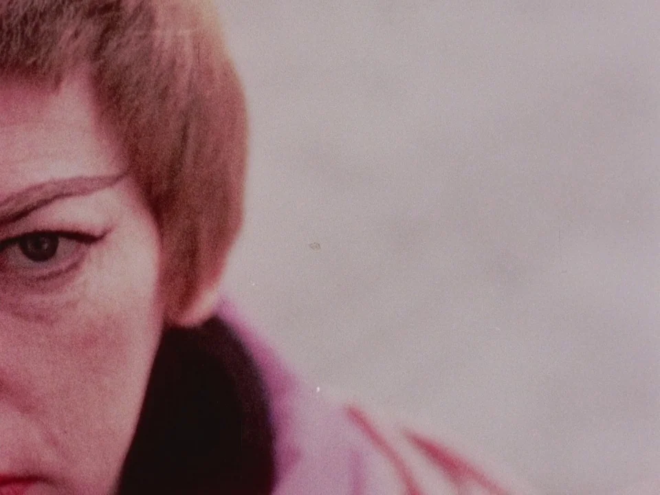 The Wormwood Star (1956) movie still: closeup — A person with short reddish-brown hair is framed in a close-up against a wall. The subject's face is…