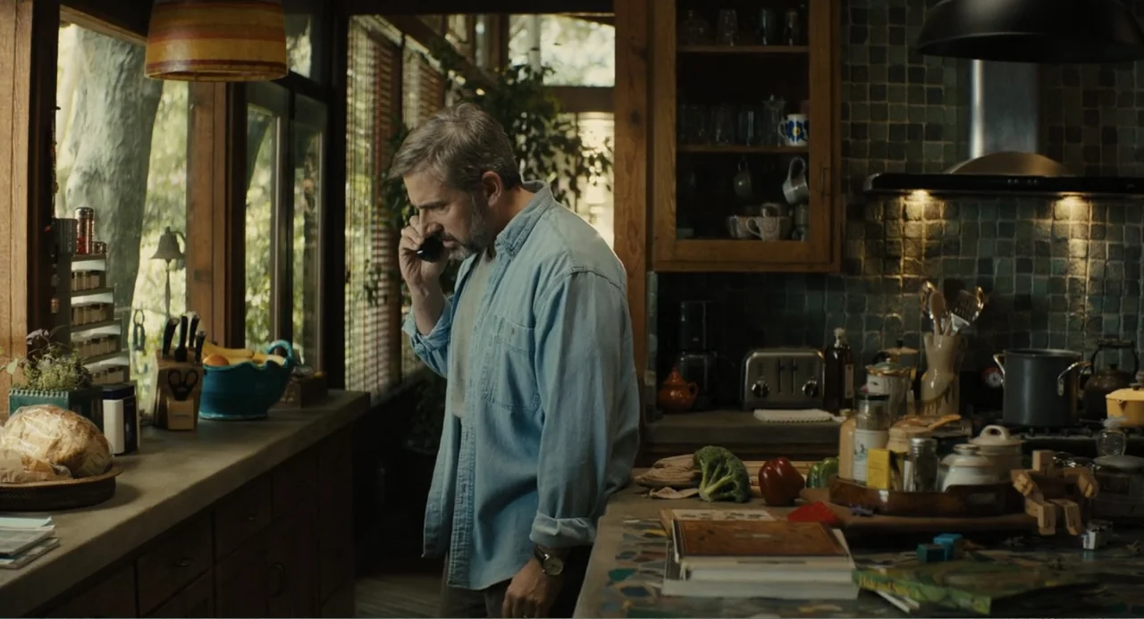 Beautiful Boy (2011) movie still: medium — A rustic kitchen features dark tile backsplashes, wood cabinetry, and a view of trees. A man in a blue…