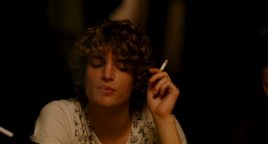 Heartbeats (Les Amours Imaginaires) (2010) movie still: medium — A person sits in a dark, indistinct interior environment at night. The subject…