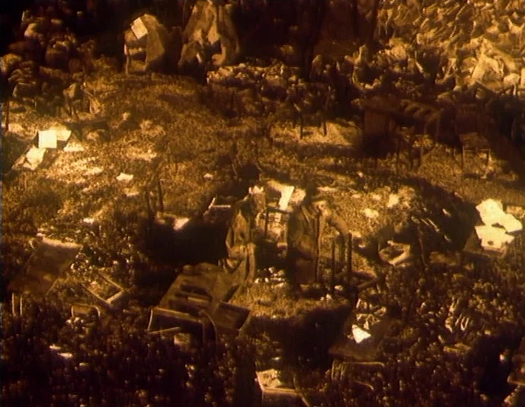 Dead Man’s Letters (1986) movie still: wide — A dark, cavernous space is filled with thousands of scattered papers and large wooden crates. The…