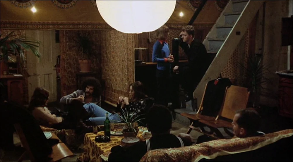 The Last Detail (1973) movie still: wide — A living room interior featuring patterned wallpaper and a prominent central paper lantern light.…