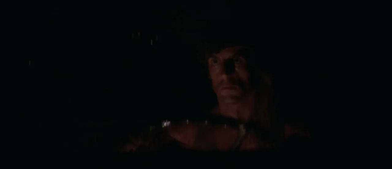 First Blood (1982) movie still: closeup — The interior of a dark car at night. A man sits at the wheel.