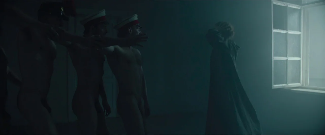 Tchaikovsky’s Wife (2022) movie still: wide — A dark, atmospheric interior with a single bright window emitting a misty glow. Three shirtless men…