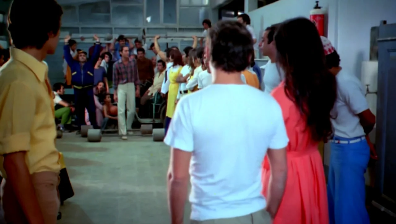 The Return of the Prodigal Son (1978) movie still: medium — A crowded interior space with tiled floors and high ceilings resembling a simple…