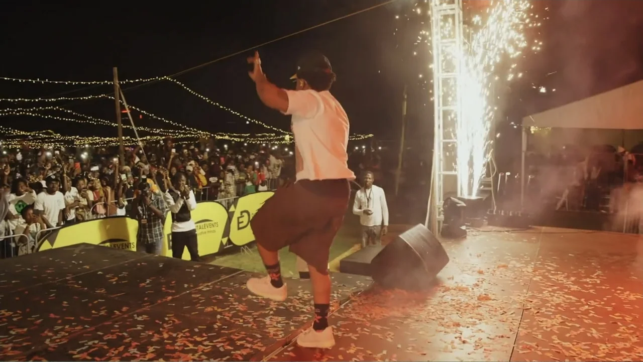 African Throne World Tour (2024) movie still: fullbody — A nighttime outdoor concert stage is covered in scattered paper confetti and stage debris.…