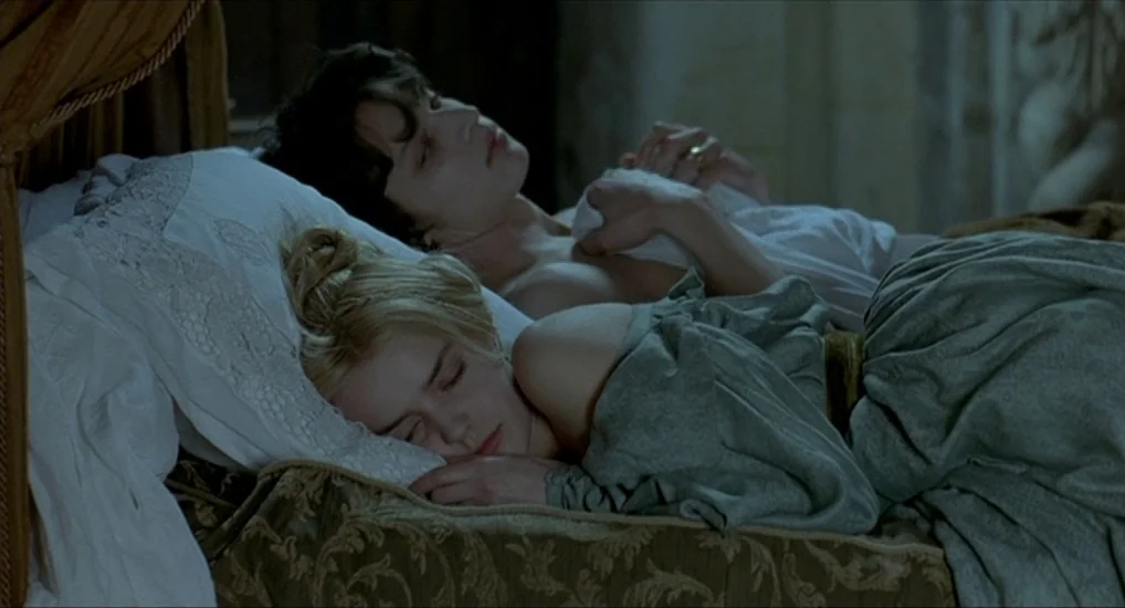 The Last Mistress (2007) movie still: medium — A period-style bed features ornate dark wooden frame details and elaborate textile covers. A man and…