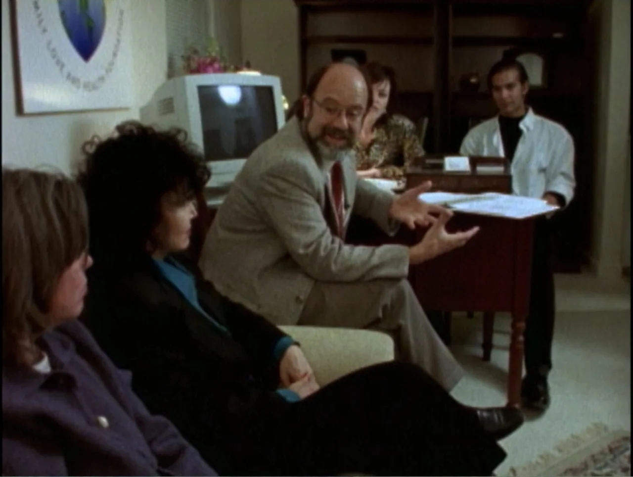 America Undercover: Life Afterlife (2000) movie still: medium — An office space with a computer monitor, wooden furniture, and paperwork on a desk.…