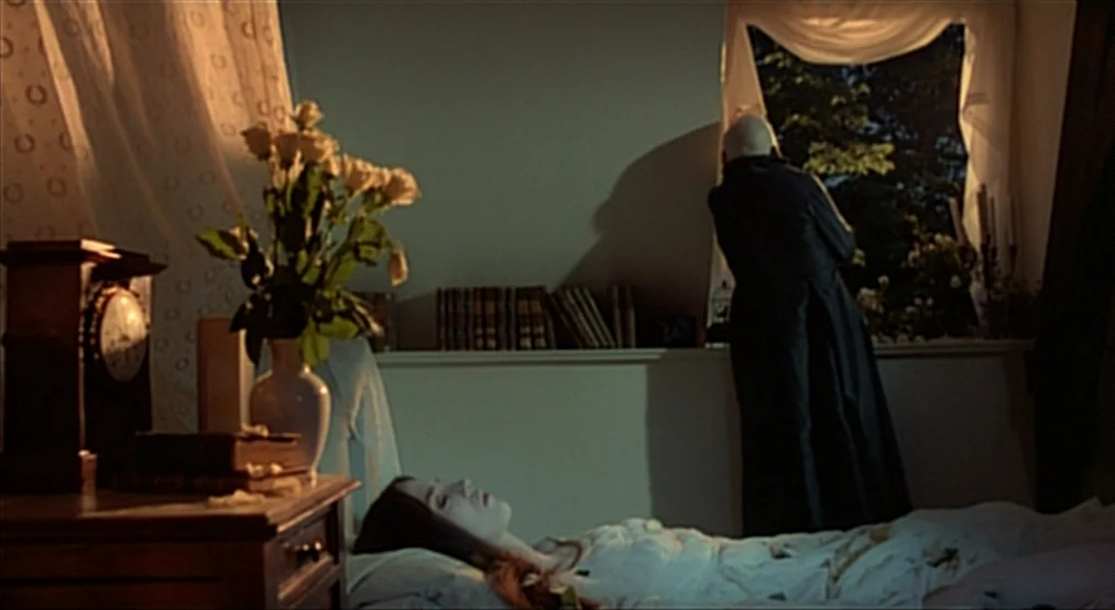 Nosferatu the Vampyre (Nosferatu Phantom Der Nacht) (1979) movie still: medium — A dimly lit room contains a resting woman and a man standing by a…