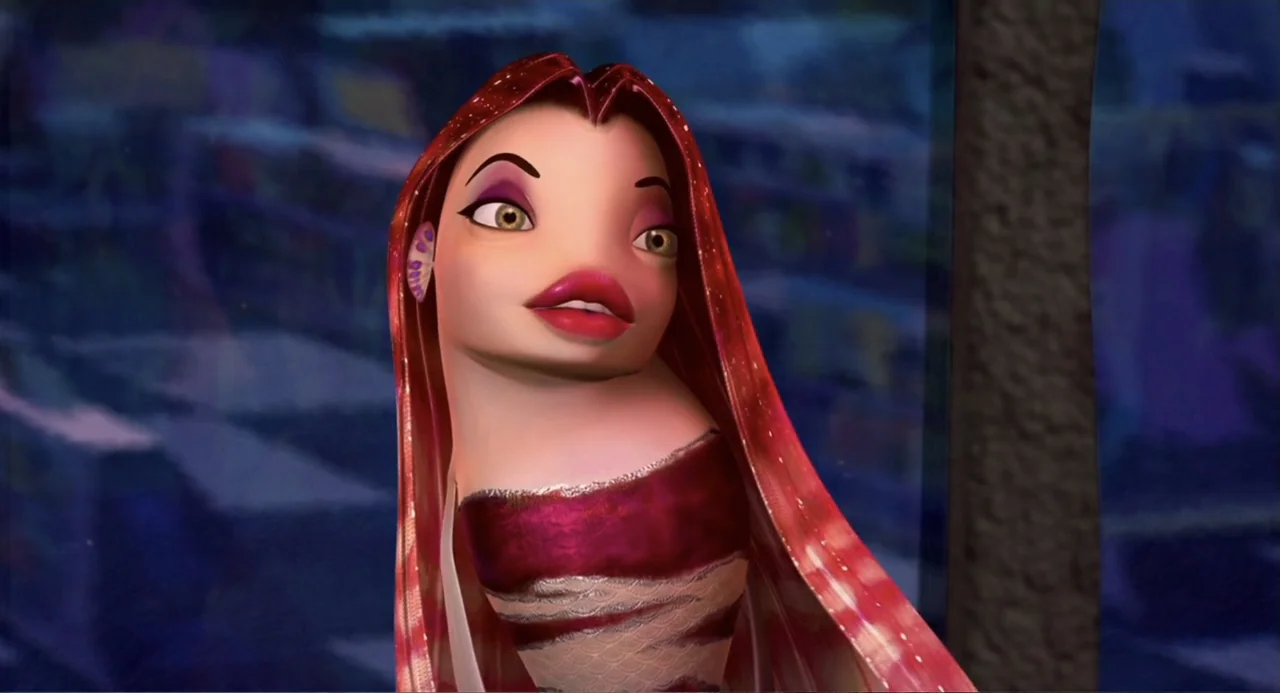 Shark Tale (2004) movie still: closeup — A close-up shot of a stylized animated fish character inside a dark room. The subject, a female fish with…