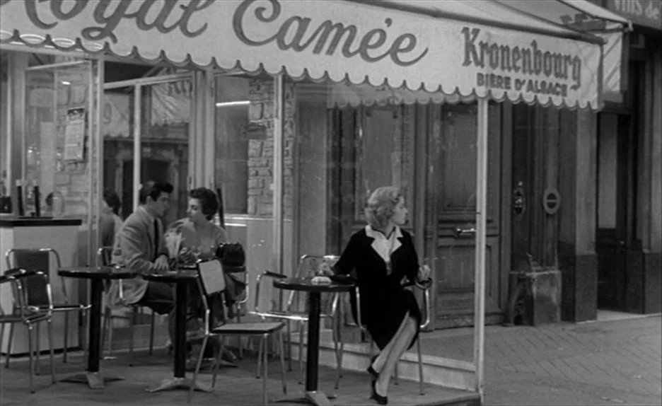 Elevator To The Gallows (Ascenseur pour l’échafaud) (1958) movie still: wide — A sidewalk cafe in a French city with a striped awning overhead at…