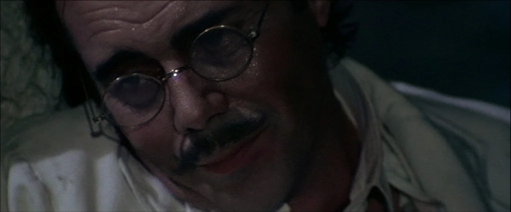 Death In Venice (1971) movie still: closeup — An interior space is dimly lit by a soft, directional light source. A middle-aged man with a mustache…