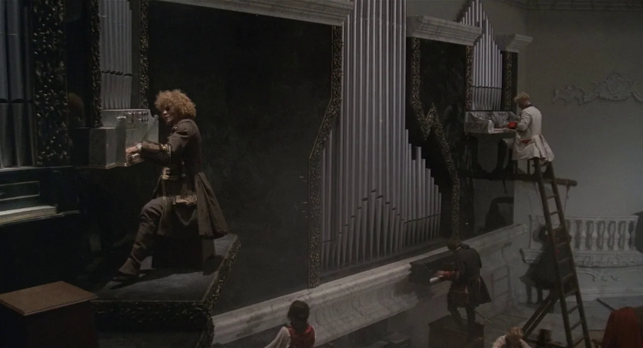 Fellini’s Casanova (1976) movie still: wide — A high-angle view of a large room featuring multiple levels of pipe organs. Several musicians play…