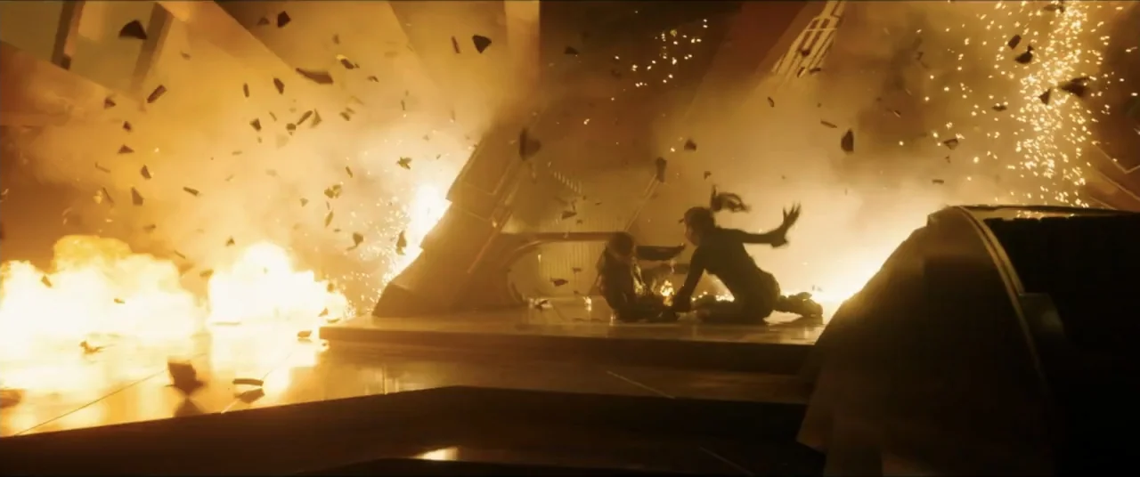 Star Trek: Section 31 (2025) movie still: wide — A high-tech metallic corridor is filled with fire and floating shrapnel from an explosion. Two…