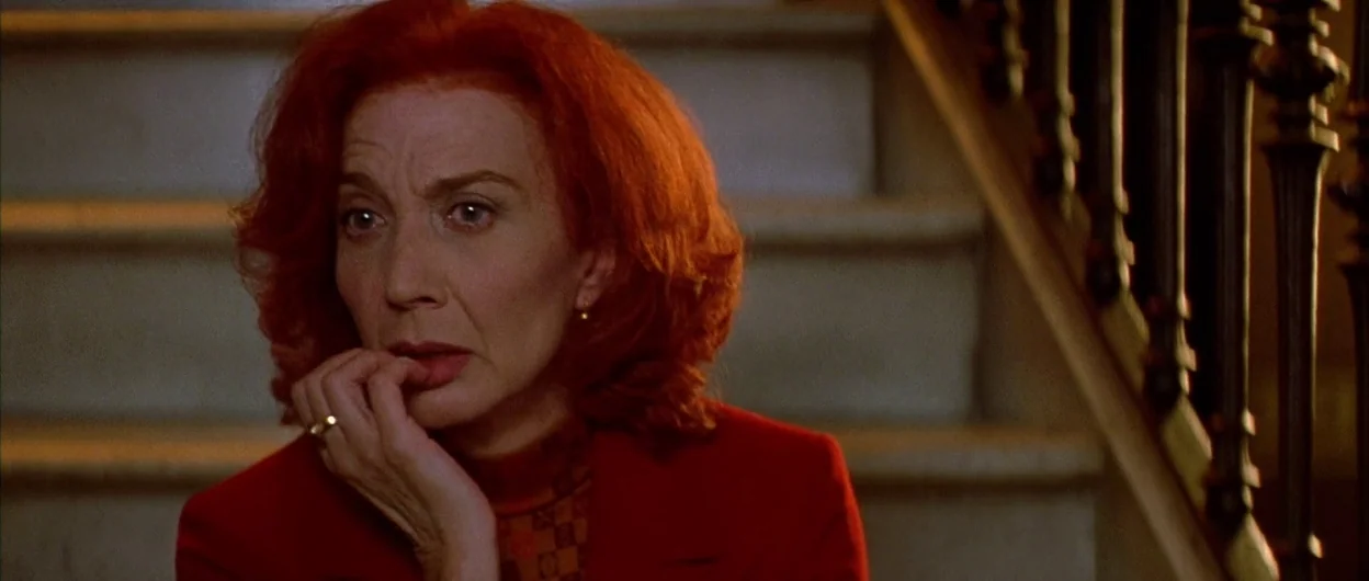 All About My Mother (1999) movie still: closeup — An interior staircase with wooden railings and stone steps provides a quiet, darkened setting. A…
