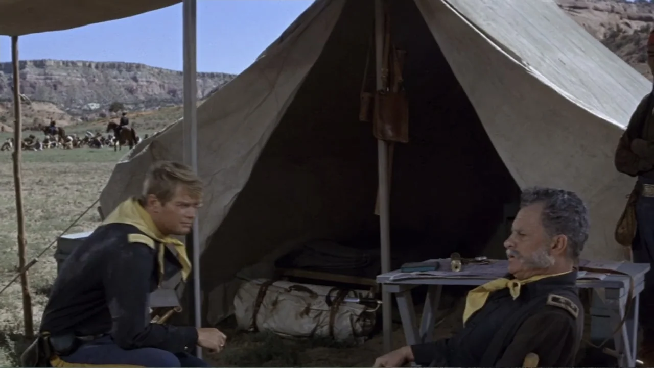 A Distant Trumpet (1964) movie still: medium — A military encampment features a large canvas tent and a small wooden table. Two cavalrymen in period…