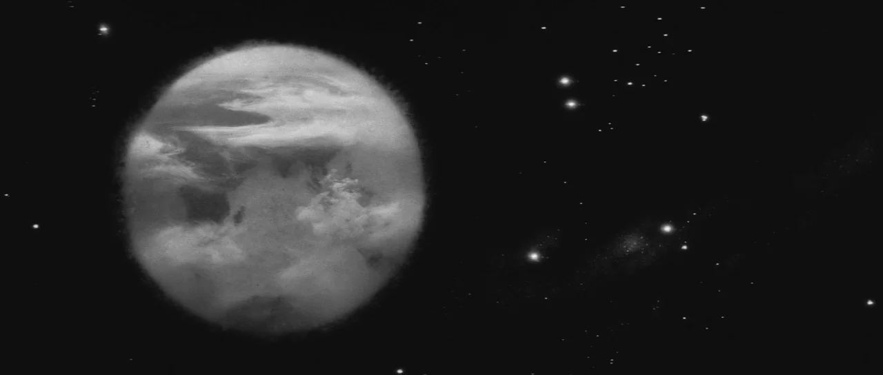 Ikarie XB 1 (1963) movie still: establishing — A large spherical celestial body with swirling cloud patterns occupies the left side. It floats…
