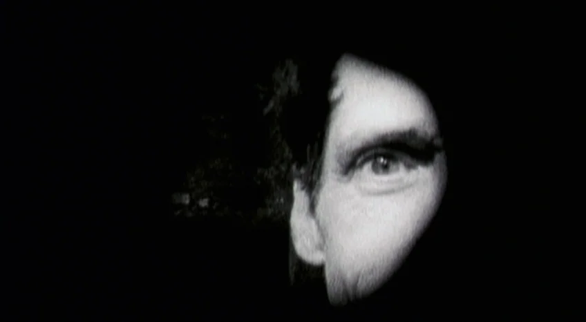Brand Upon the Brain! (2006) movie still: closeup — A man's face emerges from a dense black void into a sliver of light. The features are…