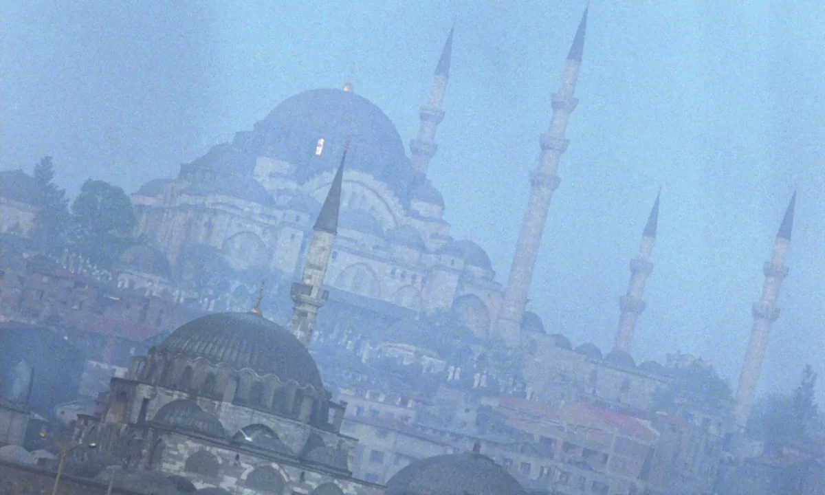 Vampyros Lesbos (1971) movie still: establishing — A large stone mosque with multiple minarets rises above a hillside covered in buildings. Thick…