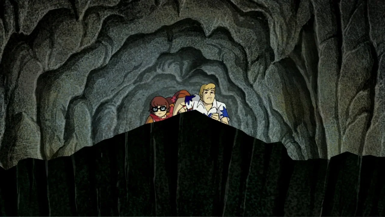 Aloha Scooby-Doo! (2005) movie still: medium — A dark rocky cavern interior with textured stone walls surrounds the two characters. A man and a…