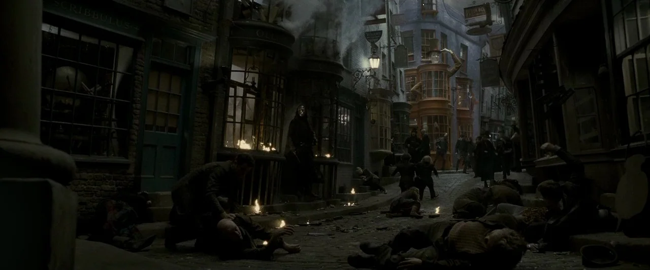Harry Potter & The Half Blood Prince (2009) movie still: wide — A narrow, debris-filled cobblestone street is lined with dark storefronts and…