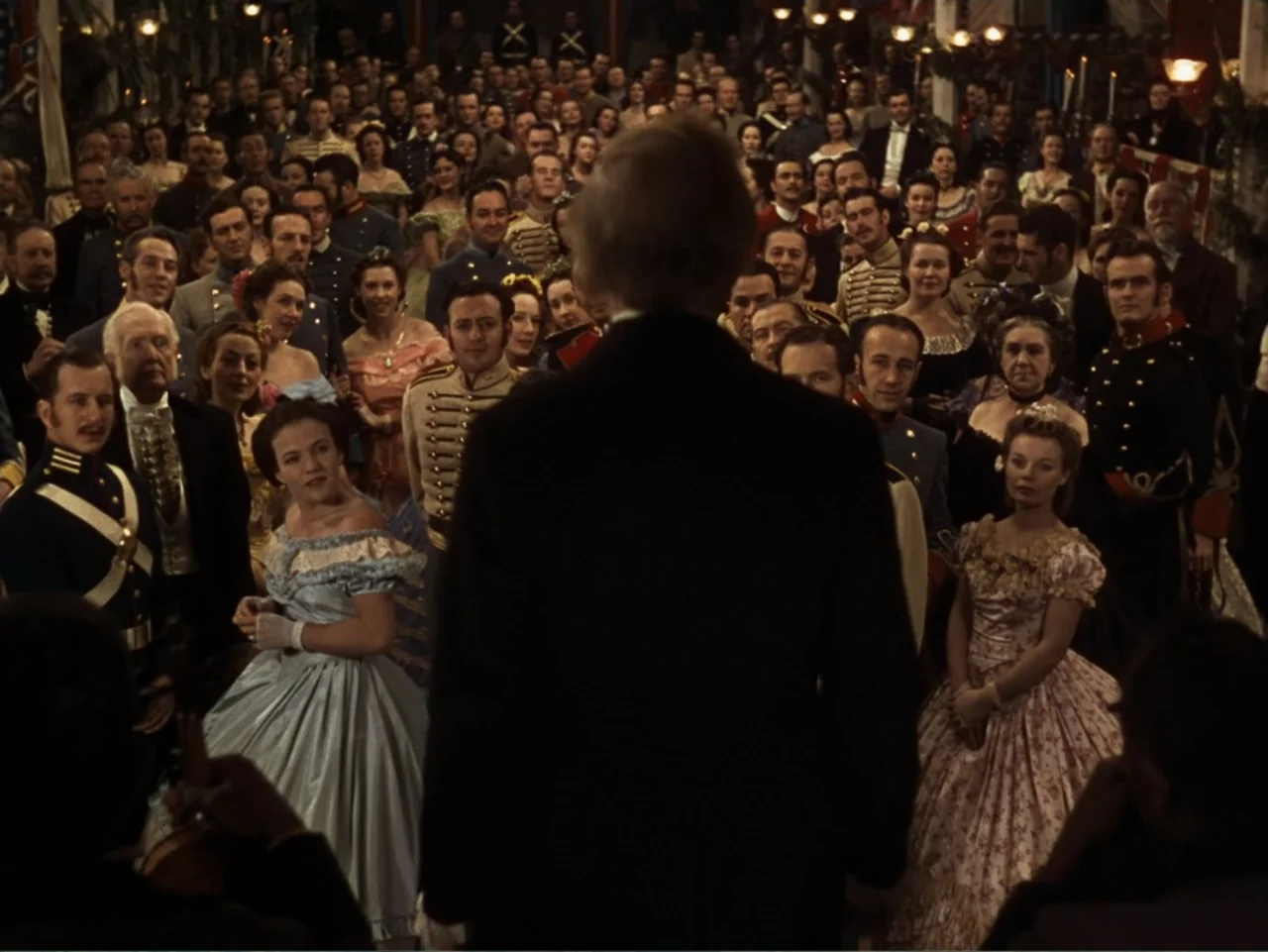 Gone with the Wind (1939) movie still: medium — A crowded 19th-century ballroom filled with guests in formal attire and period military uniforms. A…