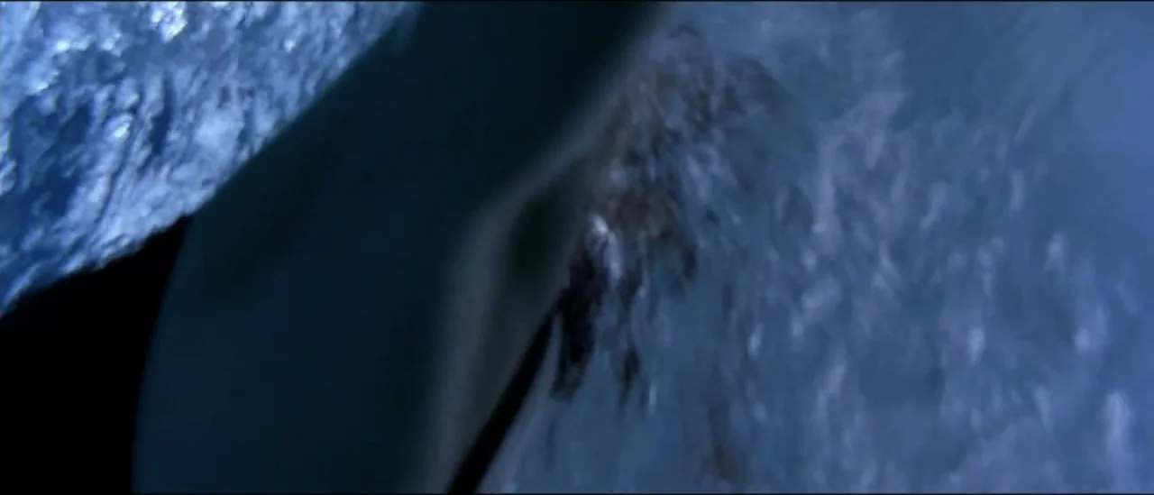 The Peacemaker (1997) movie still: closeup — An extreme closeup of turbulent dark water moving rapidly through the frame. Bubbles and foam create a…