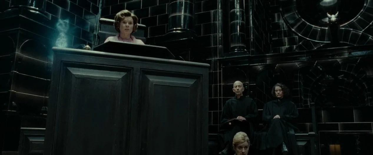 Harry Potter & The Deathly Hallows Part 1 (2010) movie still: wide — A dark subterranean chamber with glossy black tiled walls and imposing stone…