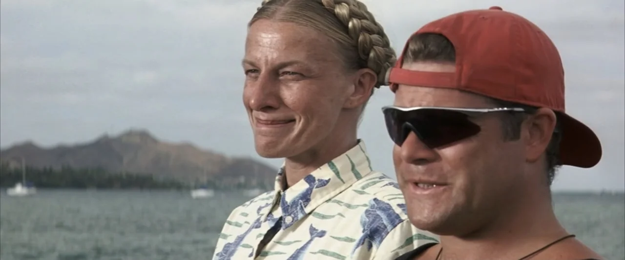 50 First Dates (2004) movie still: medium — Two people are standing in front of a coastal body of water with distant hills. A woman and a man look…
