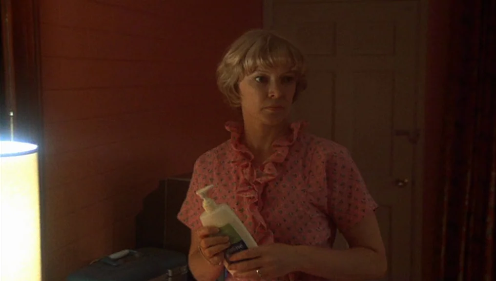 Alice Doesn’t Live Here Anymore (1974) movie still: medium — A dimly lit room features wood-paneled walls and a closed door in the background. A…
