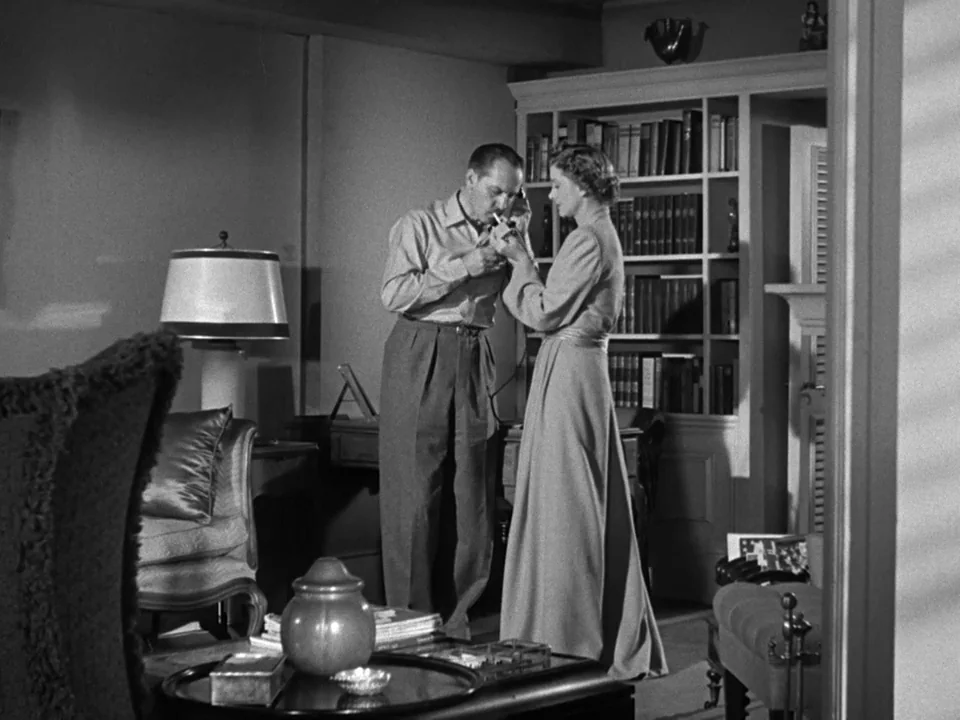 The Best Years of Our Lives (1946) movie still: medium — A dark, wood-paneled room features a floor-to-ceiling bookshelf filled with volumes of…